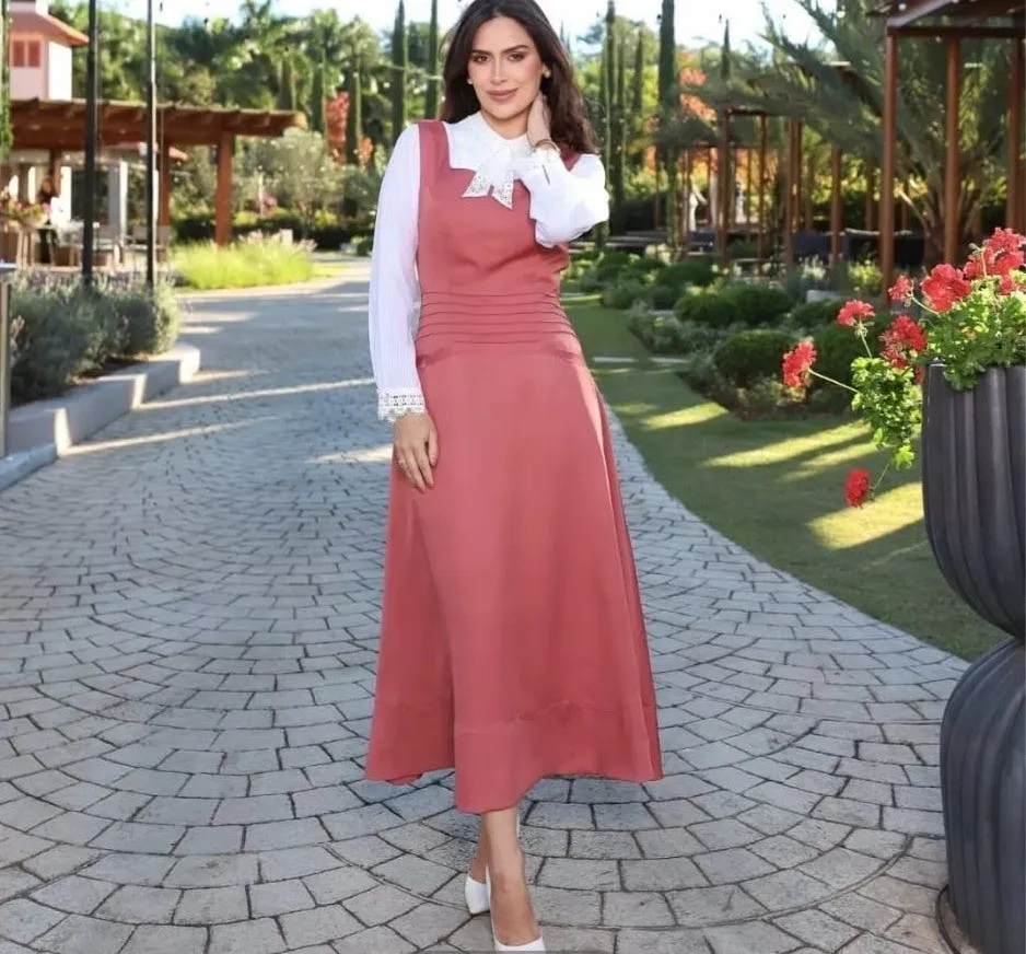 Modelo veste vestido comprido rosa-velho de alças largas, sobre blusa branca de renda