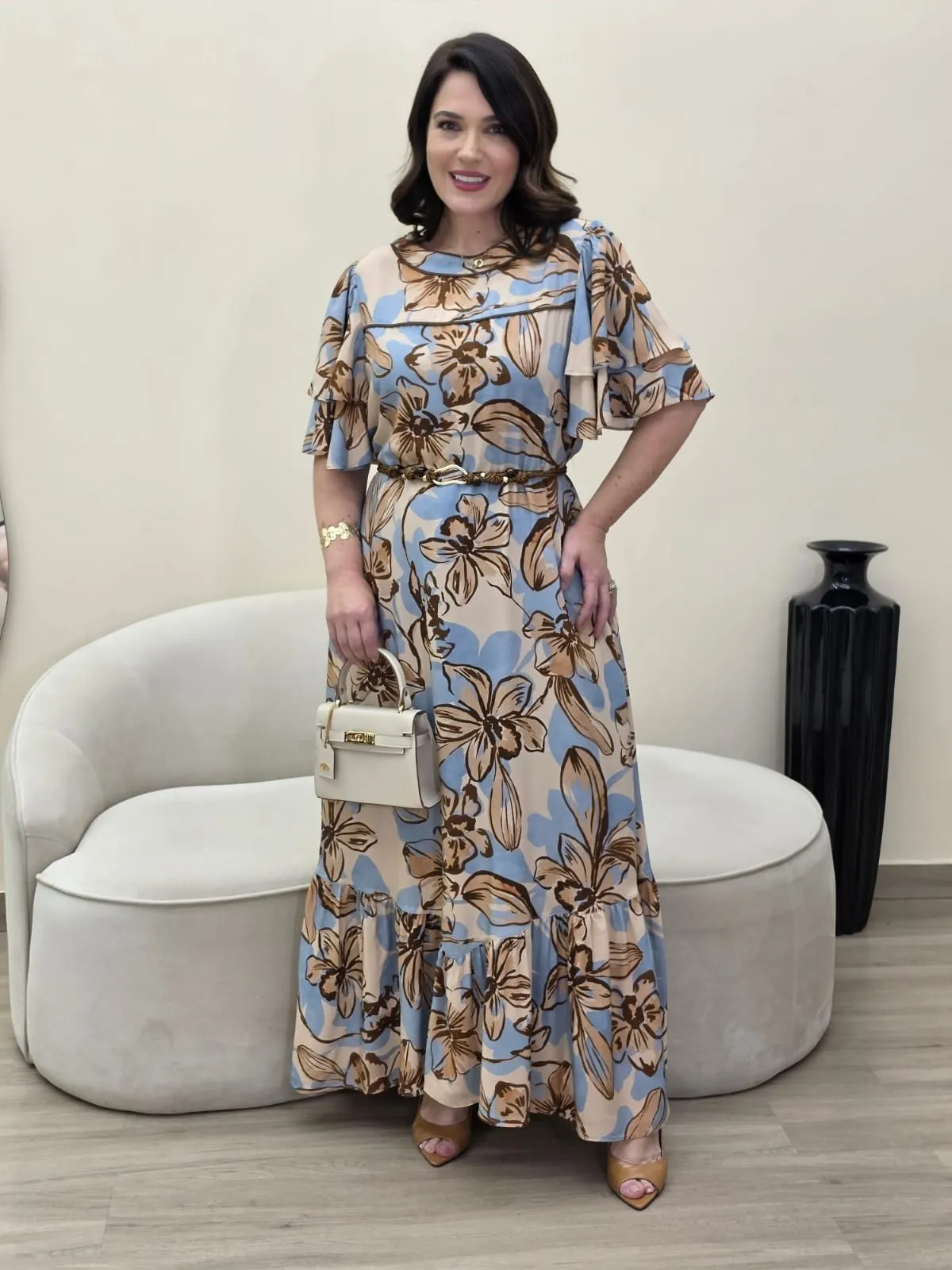Vestido comprido com estampado floral grande em caramelo sobre fundo azul-claro, com folho na barra
