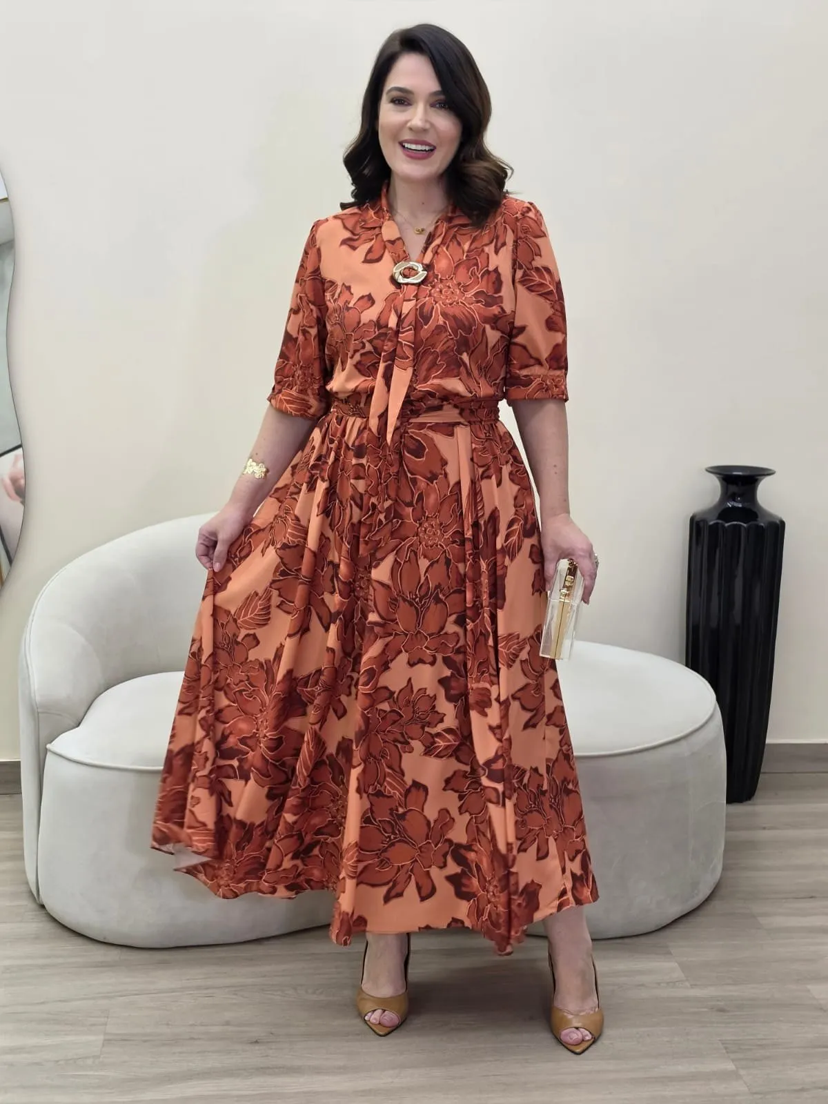 Vestido comprido com flores grandes em ferrugem sobre fundo salmão, com laço no decote e cinto