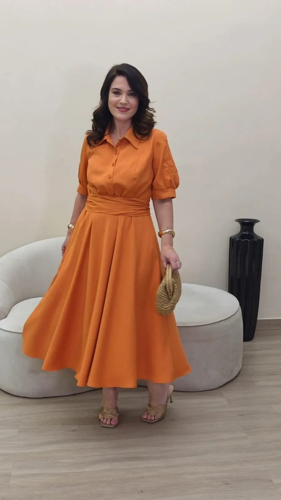 Vestido midi laranja tipo camiseiro, com gola, botões à frente, mangas balão e saia muito rodada